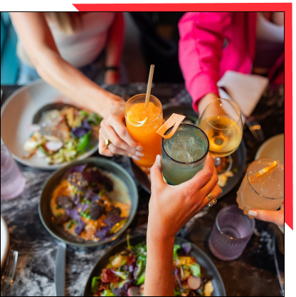 Un gruppo di persone brinda con gioia con bevande in un ristorante, celebrando insieme un'occasione speciale.